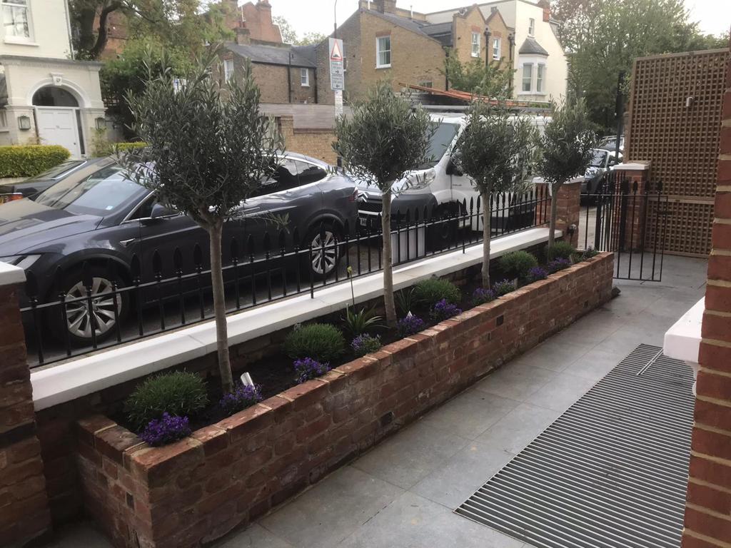 Front garden landscaping with olive trees and brick planter